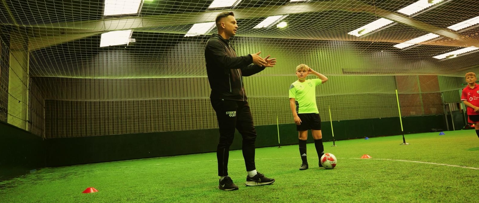 Zak Dearnley coaching young players during indoor football training session in Barnsley